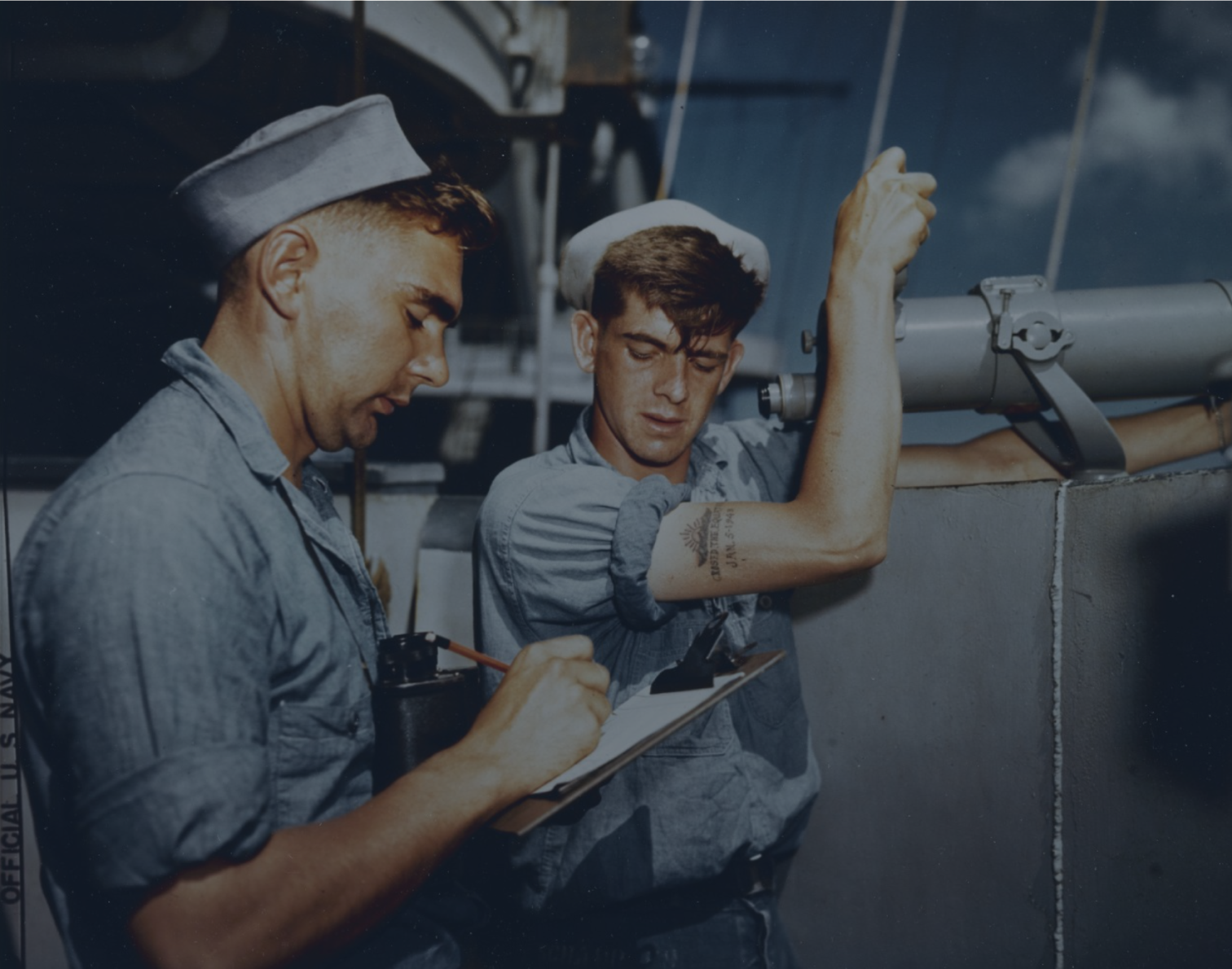 A sailor with an arm tattoo operates a cannon.